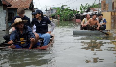 Flooding in Manila, Philippines, shows people on rafts floating past submerged houses. Photo: EU/ECHO